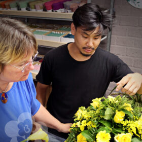 Jacqueline Boerma teaching a student how to make a Drop-Shape Funeral Arrangement