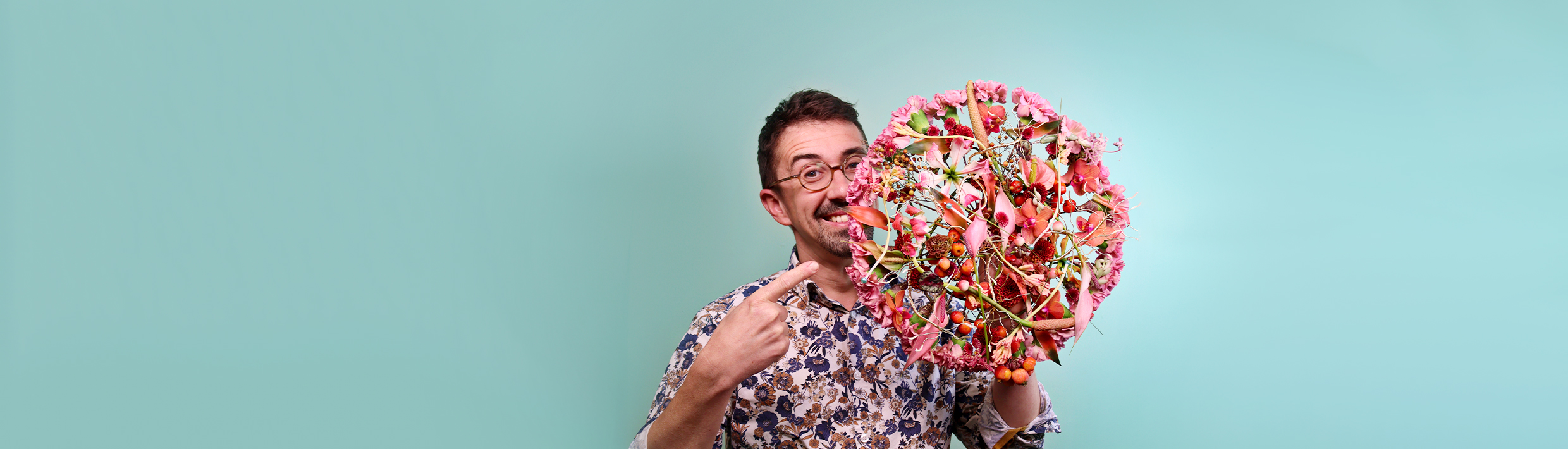French Master Florist Frédéric Dupré holding up a bridal bouquet with a beautiful color scheme